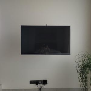 telewizor z płaskim ekranem na białej ścianie w obiekcie MG Restaurace/Luxury Apartments w mieście Mladá Boleslav