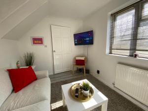 a living room with a couch and a table at Stylish 4 Bedroom House with Private Parking and Free WiFi in Milton Keynes by HP Accommodation in Milton Keynes