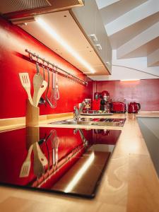 una cucina con pareti rosse e bancone con utensili di 1a Citylage-Haus im Centrum! ad Amburgo