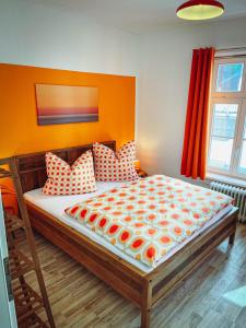 una camera da letto con un letto con cuscini arancioni e bianchi di 1a Citylage-Haus im Centrum! ad Amburgo