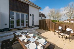 a patio with a table and chairs and a fence at Bay Retreat Villas in Padstow
