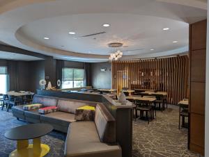 um restaurante com um sofá e mesas e um bar em SpringHill Suites by Marriott Athens West em Athens