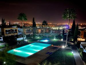 uma piscina à noite com vista para a cidade em Apartamento Vitismar CA em Guia