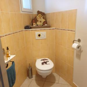 a bathroom with a toilet with a teddy bear on it at Chez Cathie à Muret in Muret