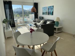 un soggiorno con tavolo e sedie bianchi di Stunning Modern 2 Bedroom Apartment - Alcazaba Lag a Estepona