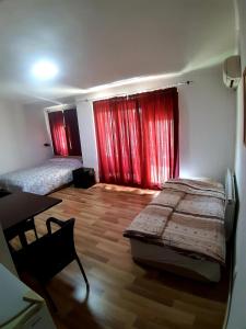 1 dormitorio con 2 camas y cortinas rojas en VN APARTMENTS OHRID en Ohrid
