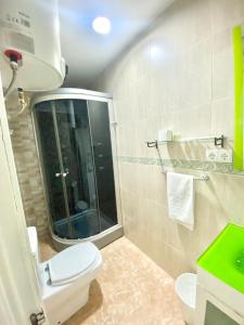 a bathroom with a toilet and a glass shower at Jaime el Conquistador Apartment in Madrid