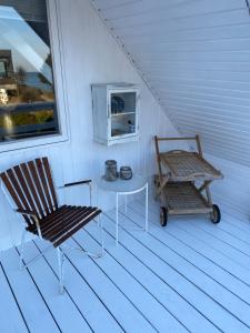 um alpendre com uma cadeira, uma mesa e uma janela em feriehus med havudsigt em Spodsbjerg