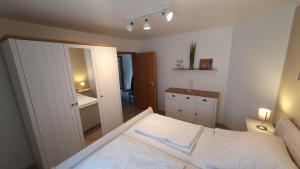 1 dormitorio con cama blanca y baño en Kaept-n-Hook, en Lemkendorf