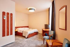 ビンペルクにあるHotel Terasaのベッド、デスク、椅子が備わるホテルルームです。