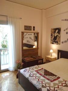 Schlafzimmer mit einem Bett mit einem Spiegel und einem Fenster in der Unterkunft Still got the blues in Athen