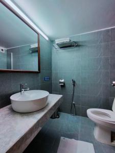 W łazience znajduje się umywalka, toaleta i lustro. w obiekcie DESHA TARC w mieście Kushtia