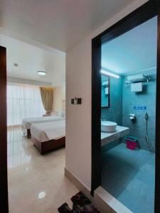 a bedroom with a bed and a bathroom with a tub at DESHA TARC in Kushtia