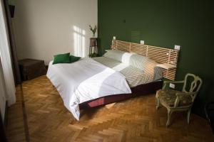 a bedroom with a large bed and a chair at CASABONA1910 bed&breakfast in Vercelli