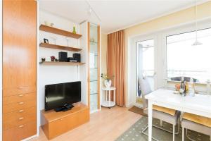 ein Wohnzimmer mit einem Schreibtisch und einem TV im Zimmer in der Unterkunft Haus Ankerlicht 3.OG Wohnung 43 in Westerland