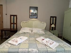 - une chambre avec un lit et 2 serviettes dans l'établissement Estancia Hosteria El Ceibo, à Florida