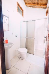 a bathroom with a toilet and a glass shower at Recanto Figueirinha in Jaguaruna