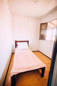 a small room with a bed in a room with a window at Recanto Figueirinha in Jaguaruna