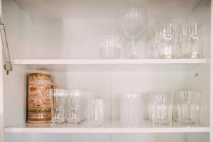 a row of glasses on a shelf in a kitchen at Recanto Figueirinha in Jaguaruna