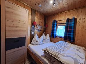 a bedroom with a bed in a wooden cabin at Chalet Panorama Tirol in Hofen