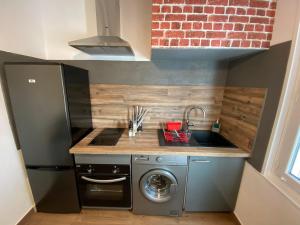 una pequeña cocina con fregadero y lavavajillas en Appartement entier au cœur du village 40m2, en Saint-Cyr-sur-Mer