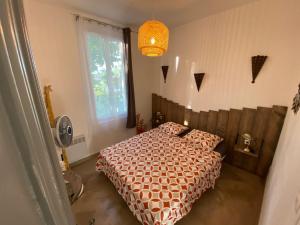 1 dormitorio con cama con edredón y ventana en Appartement entier au cœur du village 40m2, en Saint-Cyr-sur-Mer