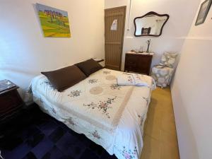 Dormitorio pequeño con cama y espejo en Estancia Hosteria El Ceibo, en Florida