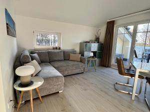 a living room with a couch and a table at Schlösschen am Schmachter See in Binz