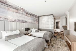 Postel nebo postele na pokoji v ubytování Atheneum Suite Hotel