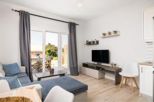 a living room with a couch and a tv at Reiki Apartments Erikousa in Ereikoússa