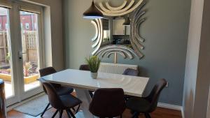uma sala de jantar com uma mesa, cadeiras e um espelho em Waters Edge, Town house in Stourport-on-Severn em Stourport