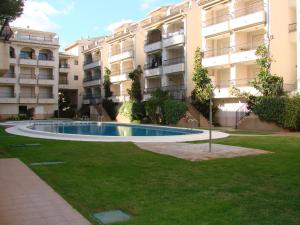 a swimming pool in a yard in front of a building at Playamar Altamar Apartments in Alcossebre