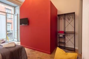 een rode muur in een kamer met een bed bij B&B o' Panar al Duomo in Napels