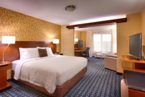 a hotel room with a bed and a flat screen tv at Fairfield Inn & Suites by Marriott Salt Lake City Midvale in Midvale