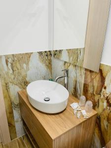 biała umywalka na drewnianym blacie w łazience w obiekcie Eloro casa vacanza w mieście Noto Marina