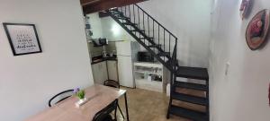 a staircase in a room with a kitchen and a table at Depto de La Lila in Salta