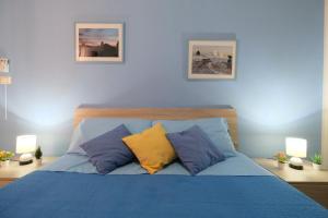 een bed met blauwe en gele kussens in een slaapkamer bij Il vecchio bastione in Aci Castello