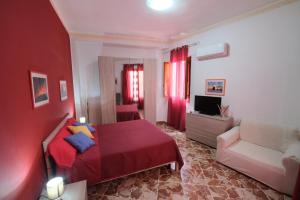 een rode slaapkamer met een bed en een bank bij Il vecchio bastione in Aci Castello