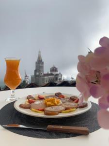 a plate of food on a table with a drink at Posada La Plazuela in Cuetzalán del Progreso