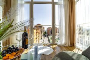 Habitación con mesa, botella de vino y ventana en Perla de Malagueta, en Málaga