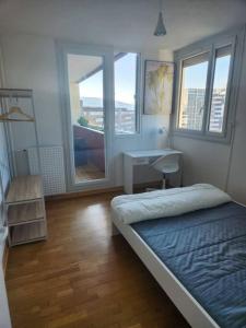sypialnia z łóżkiem, biurkiem i oknami w obiekcie Appartement T4 très spacieux w Grenoble