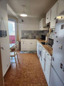 uma cozinha com armários brancos e piso em madeira em Appartement T4 très spacieux em Grenoble