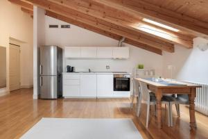 a kitchen with a table and a stainless steel refrigerator at Apartments Trieste Centro I 2 in Trieste