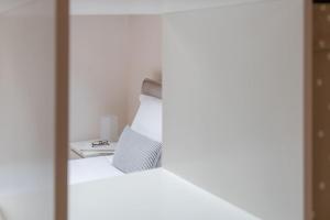 a bedroom with a white bed and a mirror at Apartments Trieste Centro I 2 in Trieste +26 photos