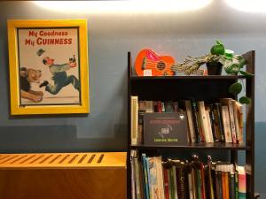 a book shelf filled with books and a picture of a monkey at Koala Hostel in Milan