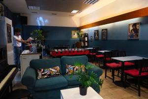 a man standing in a restaurant with a couch at Koala Hostel in Milan