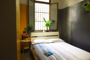 a bedroom with a bed and a window with a plant at Koala Hostel in Milan