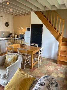 a kitchen and dining room with a table and chairs at Le Nid de Bercé in Jupilles