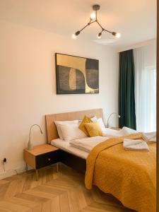 1 dormitorio con 1 cama grande con manta amarilla en Apartamenty Kalina z widokiem na góry - Kilińskiego en Świeradów-Zdrój