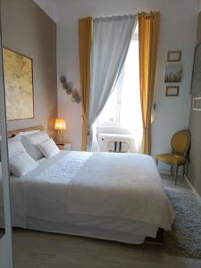 Un dormitorio con una gran cama blanca y una ventana. en Luca's Vatican Hospitality, en Roma
